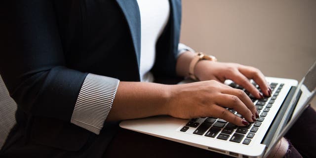 person typing on laptop keyboard