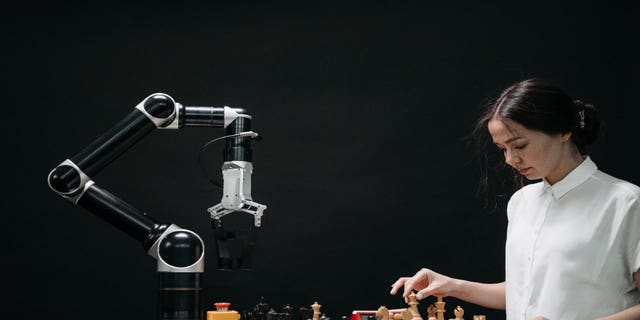 Girl plays chess with a robot