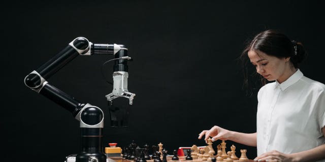 Girl plays chess with a robot