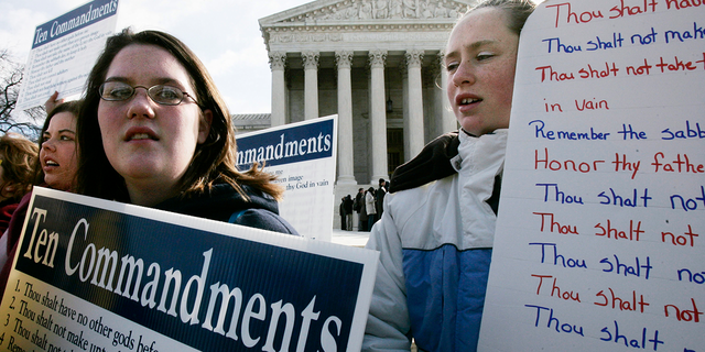 Anna Dollar (2nd L) of Boone, NC, and Deanna Gosnell (R) of Avery, North Carolina, hold posters during a rally in front of the U.S. Supreme Court to support the Ten Commandments March 2, 2005 in Washington, DC. The Supreme Court heard two cases on whether Ten Commandments monuments should be displayed on government properties. 