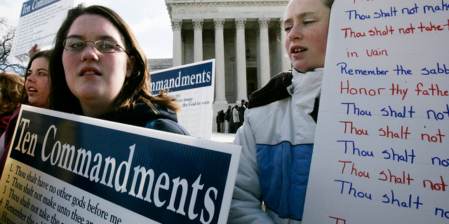 Anna Dollar (2nd L) of Boone, NC, and Deanna Gosnell (R) of Avery, North Carolina, hold posters during a rally in front of the U.S. Supreme Court to support the Ten Commandments March 2, 2005 in Washington, DC. The Supreme Court heard two cases on whether Ten Commandments monuments should be displayed on government properties.