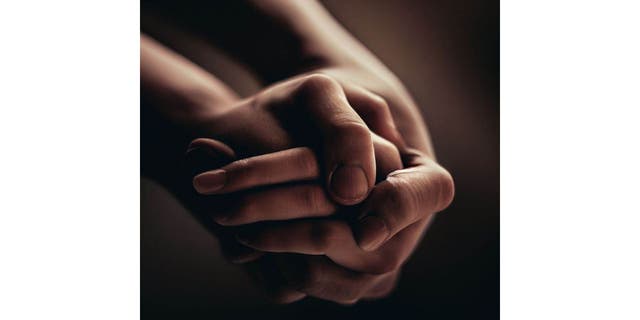 Two hands clasped together
