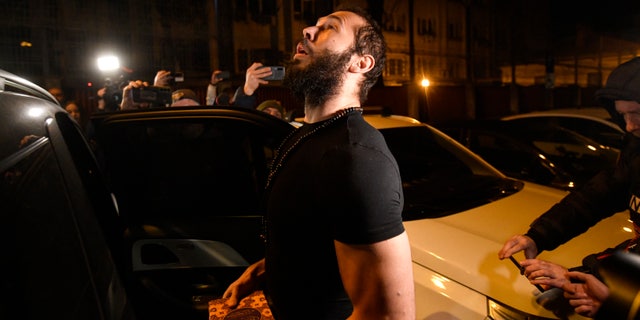 Andrew Tate es liberado de la prisión romana y puesto bajo arresto domiciliario 5 Andrew Tate mira sosteniendo un Corán después de salir de un centro de detención policial en Bucarest, Rumania, el viernes 31 de marzo de 2023. Un funcionario dijo el viernes que Tate, una personalidad divisiva de Internet que pasó meses en una prisión rumana bajo sospecha de crimen organizado y derechos humanos. trata de personas, ha ganado un recurso para sustituir su detención por arresto domiciliario. (Foto AP/Alexandru Dobre)