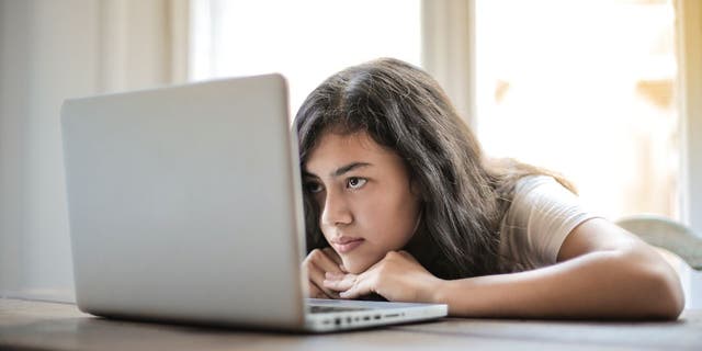 Woman with her head down on her laptop.