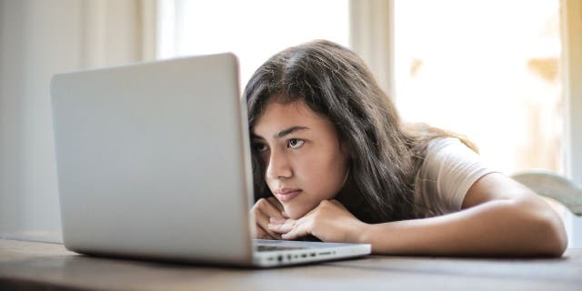 Woman with her head down on her laptop.