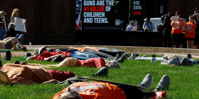 Demonstrators stage a "die-in" to protest the National Rifle Association annual convention, outside the Indianapolis Convention Center in Indianapolis, Indiana, U.S., April 15, 2023. 