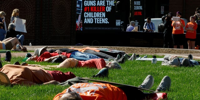 Demonstrators stage a "die-in" to protest the National Rifle Association annual convention, outside the Indianapolis Convention Center in Indianapolis, Indiana, U.S., April 15, 2023.