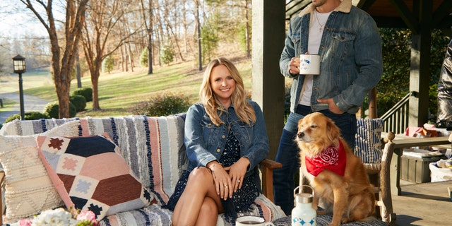 Miranda Lambert sitting on a porch with her husband Brendan McLoughlin and a dog.