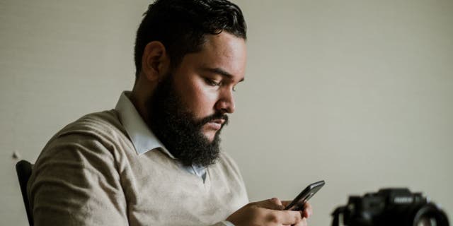 Man looks down at his phone