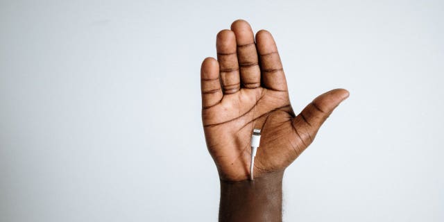 iPhone cord attached to hand of person