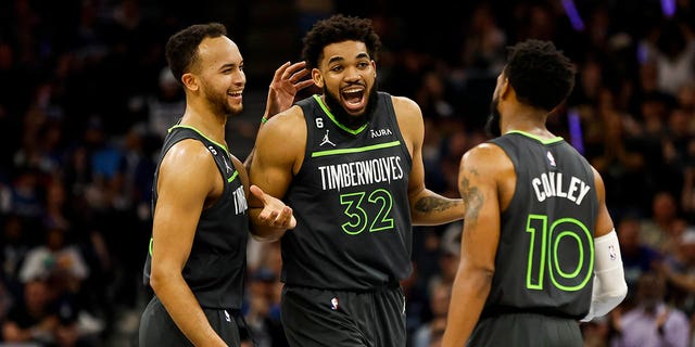 Karl-Anthony Towns #32 of the Minnesota Timberwolves celebrates fouling the Oklahoma City Thunder with teammates Kyle Anderson #5 and Mike Conley #10 in the second quarter of the NBA Play-In game at Target Center on April 14, 2023, in Minneapolis, Minnesota.