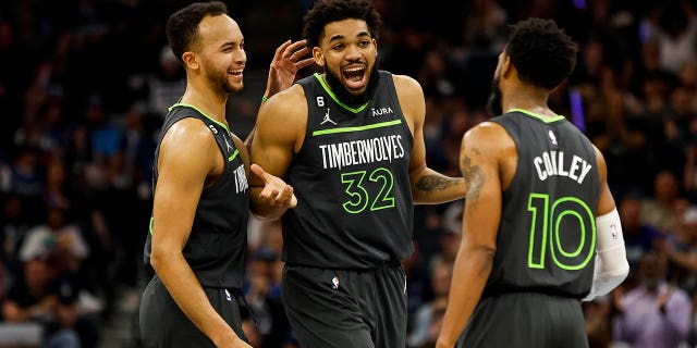 Karl-Anthony Towns #32 of the Minnesota Timberwolves celebrates drawing a foul against Oklahoma City Thunder with teammates Kyle Anderson #5 and Mike Conley #10 in the second quarter of the NBA Play-In game at Target Center on April 14, 2023, in Minneapolis, Minnesota.