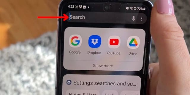 Red arrow pointing at search tab on android phone