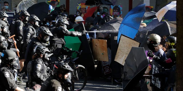 Police pepper spray Black Lives Matter protesters on July 25, 2020, in Seattle, Washington. A panel of police, citizens, and accountability experts are pressuring the Seattle Police Department to offer a sincere, public apology.