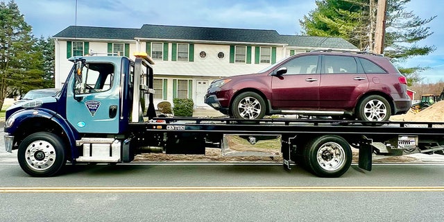 State police remove a stolen vehicle from a home in western Massachusetts on Wednesday.