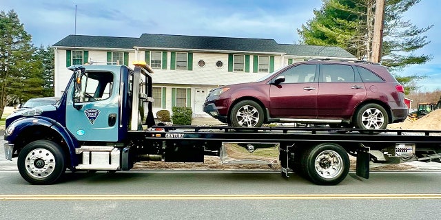 State police remove a stolen vehicle from a home in western Massachusetts on Wednesday.