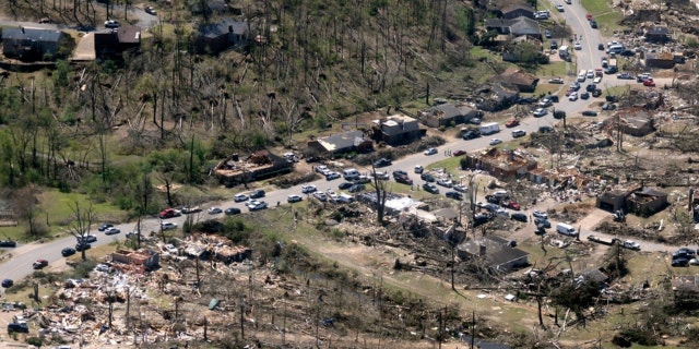 Cars line up along the road as cleanup continues from Friday's tornado damage, Sunday, April 2, 2023, in west Little Rock, Ark. 