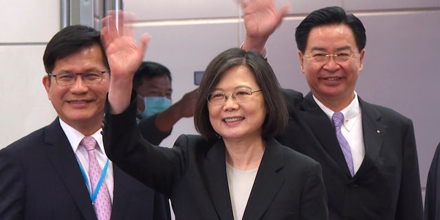In this image made from video, Taiwan's Presidential office secretary general Lin Chia-lung, left, President Tsai Ing-wen, center, and Foreign Minister Joseph Wu wave before Tsai's departure on an overseas trip at Taoyuan International Airport in Taipei, Taiwan, Wednesday, March 29, 2023. 