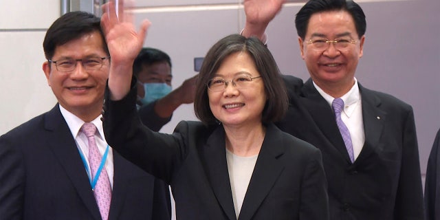 In this image made from video, Taiwan's Presidential office secretary general Lin Chia-lung, left, President Tsai Ing-wen, center, and Foreign Minister Joseph Wu wave before Tsai's departure on an overseas trip at Taoyuan International Airport in Taipei, Taiwan, Wednesday, March 29, 2023. 