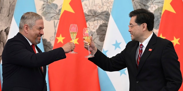 Honduras Foreign Minister Eduardo Enrique Reina Garcia, left, and Chinese Foreign Minister Qin Gang, raise a toast following the establishment of diplomatic relations between the two countries.