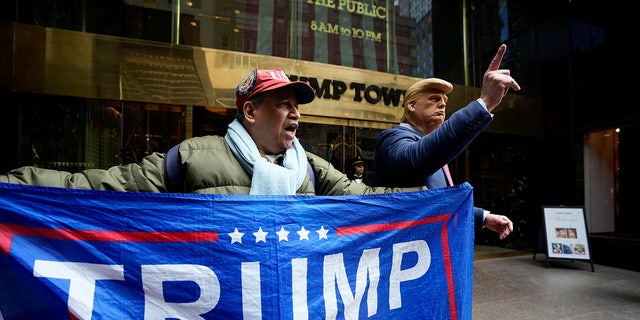 A supporter of former President Trump and a man impersonating the former president stand outside of Trump Tower on March 31, 2023, in New York. Trump will be arraigned Tuesday in connection to an alleged hush money payment case.