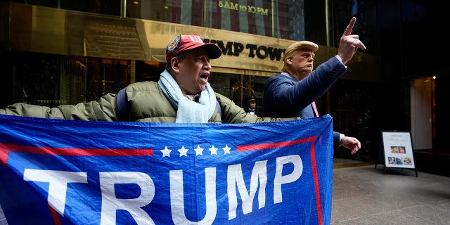 A supporter of former President Trump and a man impersonating the former president stand outside of Trump Tower on March 31, 2023, in New York. Trump will be arraigned Tuesday in connection to an alleged hush money payment case.