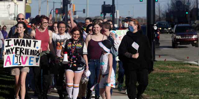 More than 100 people march around the Kansas Statehouse on the annual Transgender Day of Visibility, on March 31, 2023, in Topeka, Kansas. While the event was a celebration of transgender identity, it also was a protest against proposals before the Kansas Legislature to roll back transgender rights. 