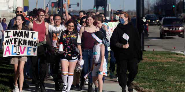 More than 100 people march around the Kansas Statehouse on the annual Transgender Day of Visibility, on March 31, 2023, in Topeka, Kansas. While the event was a celebration of transgender identity, it also was a protest against proposals before the Kansas Legislature to roll back transgender rights.