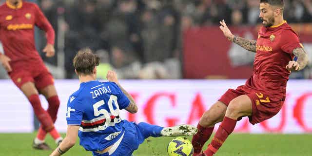 Leonardo Spinazzola, right, is tackled by Sampdorias Alessandro Zanoli in a soccer match between Roma and Sampdoria at the Rome Olympic stadium on April 2, 2023.