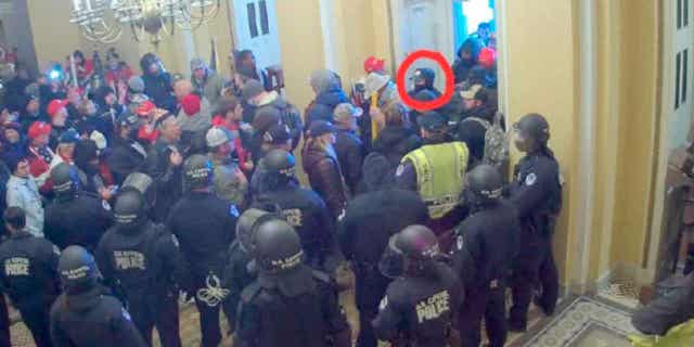 David Elizalde, circled in red, appears on security video inside the U.S. Capitol on Jan. 6, 2021, in Washington. The FBI says Elizalde was stationed on a Navy aircraft carrier when he joined the attack on the building.