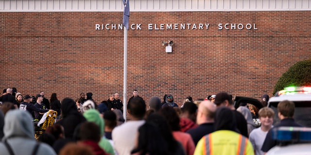 Students and police gather outside Richneck Elementary School after a shooting, Jan. 6, 2023, in Newport News, Virginia. Teacher Abby Zwerner says school administration ignored warning signs before a 6-year-old shot her in class.