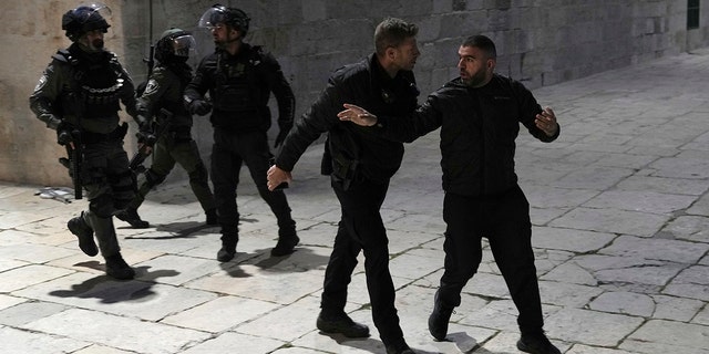Izraelska policija odvodi palestinskog vjernika u sklopu džamije Al-Aqsa nakon racije u starom gradu Jeruzalema tijekom svetog muslimanskog mjeseca ramazana, srijeda, 5. travnja 2023. 