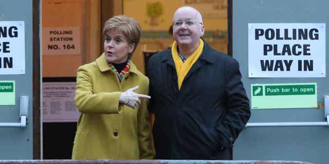 Scottish First Minister Nicola Sturgeon poses for the media with husband Peter Murrell, outside polling station in Glasgow, Scotland, on Dec. 12, 2019. British media are reporting that Murrell has been arrested in a finance probe on April 5, 2023.