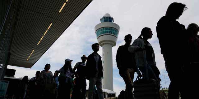 Para pemudik mengantre panjang di luar gedung terminal untuk check in dan naik pesawat di Bandara Schiphol Amsterdam, Belanda, pada 21 Juni 2022. Hakim memutuskan pada 5 April 2023 bahwa pemerintah Belanda tidak bisa memerintahkan Bandara Schiphol untuk mengurangi jumlah penerbangan.