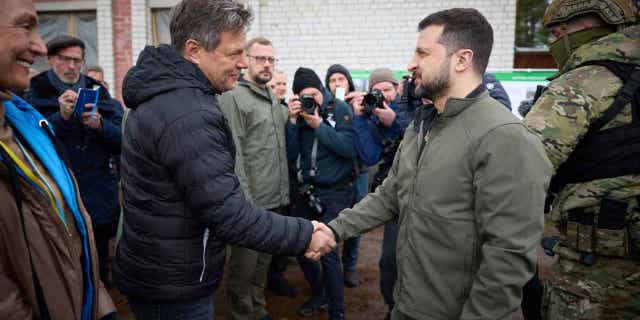 Ukrainian President Volodymyr Zelenskyy, right, shakes hands with German economy and climate minister Robert Habeck in the Chernihiv region of Ukraine, on April 3, 2023. Olaf Scholz's spokesman on April 5, 2023, defended his country's record on delivering arms to Ukraine after Habeck, a pre-war advocate of providing Ukraine with arms, said this week he was "deeply ashamed" that it took Germany so long to do so.