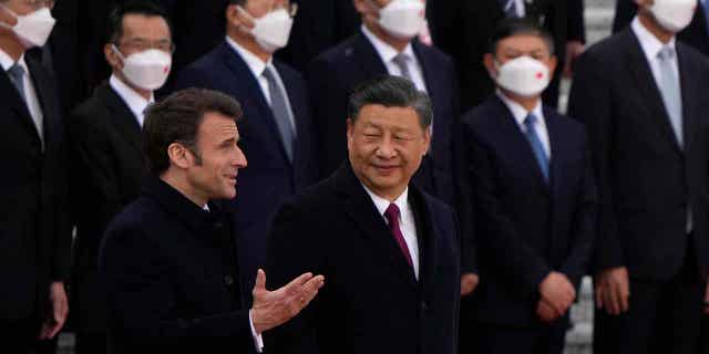 French President Emmanuel Macron, bottom left, chats with Chinese President Xi Jinping during a welcome ceremony held outside the Great Hall of the People in Beijing, on April 6, 2023.