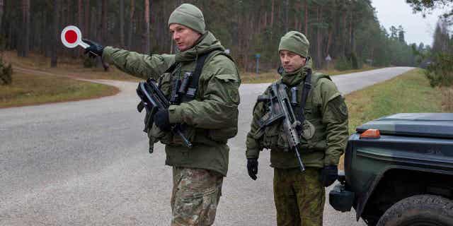 Lithuanian soldiers patrol a road near the Lithuania-Belarus border near the village of Jaskonys, Druskininkai district nearly 100 miles south of the capital Vilnius, Lithuania, on Nov. 13, 2021. 