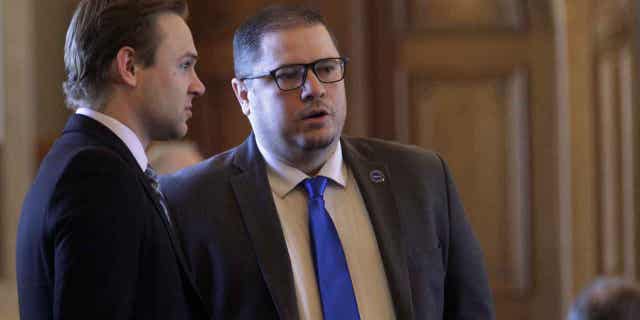 State Reps. Avery Anderson, left, and Nick Hoheisel talk during a break in the Houses work on April 6, 2023. Both support a proposal that would prevent state agencies from using environmentally and socially conscious factors in investing their funds. 
