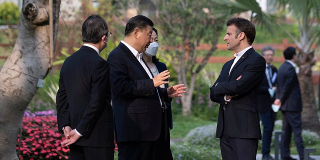 Chinese President Xi Jinping, second left, and French President Emmanuel Macron talk in the garden of the Guandong province governor's residence, in Guangzhou, China, Friday, April 7, 2023.
