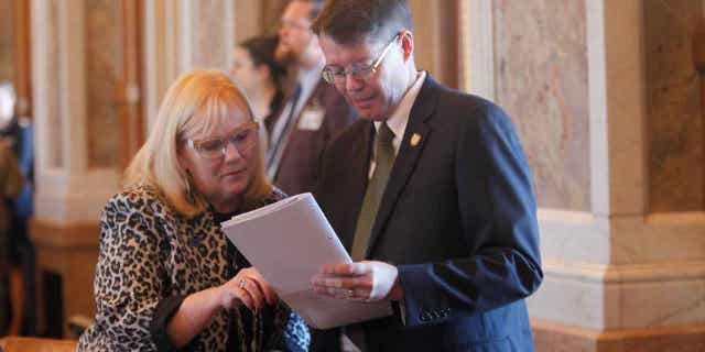 Kansas state Reps. Susan Concannon, left, and Fred Patton, right, confer during a session of the House, on April 6, 2023, at the Statehouse in Topeka, Kansas. Both Concannon and Patton supported a bill approved by lawmakers that would require abortion providers to tell patients that medication abortions can be "reversed" once they are started.