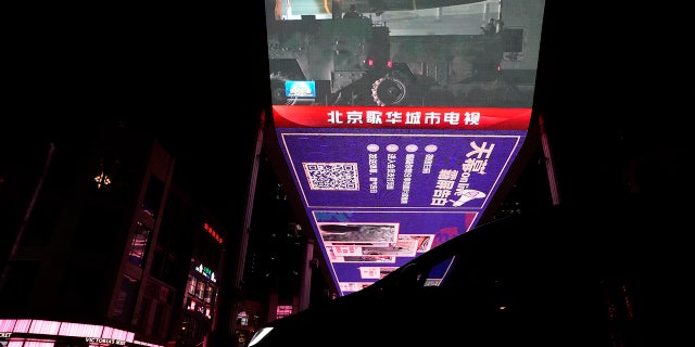 An outdoor screen shows the recently concluded Joint Sword exercise around Taiwan during the evening news broadcast in Beijing. China's military declared Monday it is "ready to fight" after completing the three-day exercise.