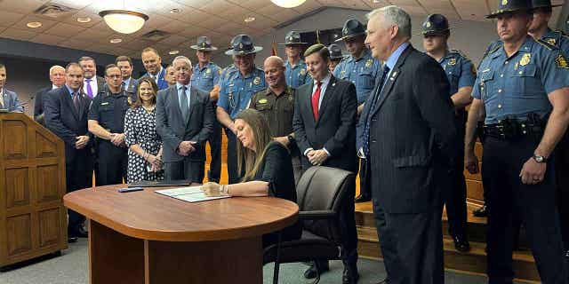 Gov. Sarah Huckabee Sanders signs legislation on April 11, 2023, in Little Rock, Arkansas, that will overhaul the states sentencing laws. The new law will eliminate parole eligibility for certain violent offenses.