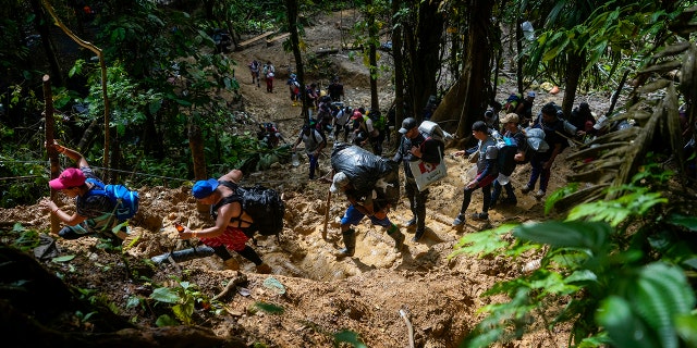 FILE - Migrants, mostly Venezuelans, walk across the Darien Gap from Colombia into Panama hoping to reach the U.S. on Oct. 15, 2022. 