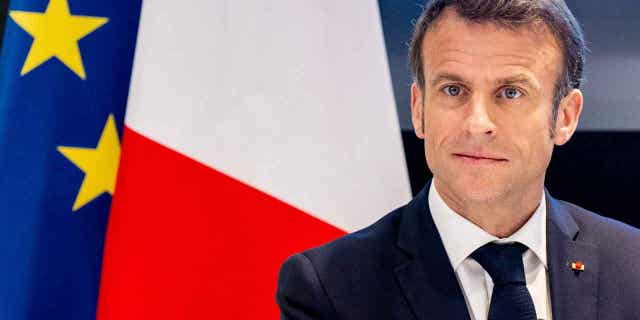 French President Emmanuel Macron visits the University of Amsterdam, on April 12, 2023. Police tackled and detained a protestor who was running toward Macron.