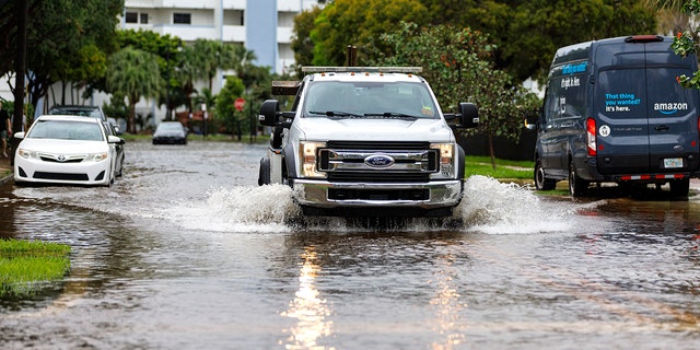 A tow truck goes through the flooded road cause by heavy rains at North Bay Rd and 179th Dr. in Sunny Isles Beach, Fla., Wednesday, April 12, 2023. 