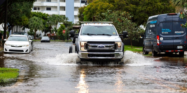 A tow truck goes through the flooded road cause by heavy rains at North Bay Rd and 179th Dr. in Sunny Isles Beach, Fla., Wednesday, April 12, 2023. 