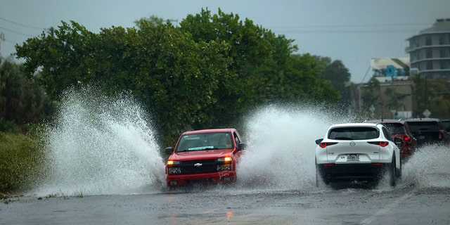 A truck drives through flooding in Little Haiti during a rainstorm, Wednesday, April 12, 2023, in Miami. 