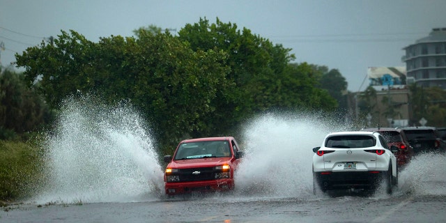 A truck drives through flooding in Little Haiti during a rainstorm, Wednesday, April 12, 2023, in Miami. 