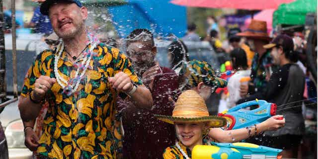 A man sprays water on a tourist to celebrate Songkran in Thailand's Prachinburi province.