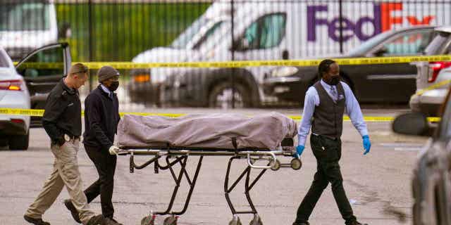 A body is taken from the scene of a shooting at a FedEx Ground facility in Indianapolis, Indiana, on April 16, 2021. The son of one of the men killed in the shooting filed a lawsuit on April 13, 2023, with two survivors against the distributor of the magazine used by the gunman.